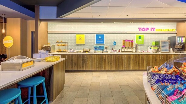 A breakfast counter with a sign reading "TOP IT BREAKFAST" and various food items displayed. - Tru By Hilton Panama City Beach (Panama City Beach)