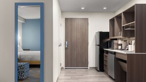 Una cocina moderna con microondas, refrigerador y armarios de madera.