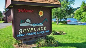 Ein hölzernes Schild mit der Aufschrift 'Welcome' und 'SUNPLACE DEEP CREEK LAKE, MD.'