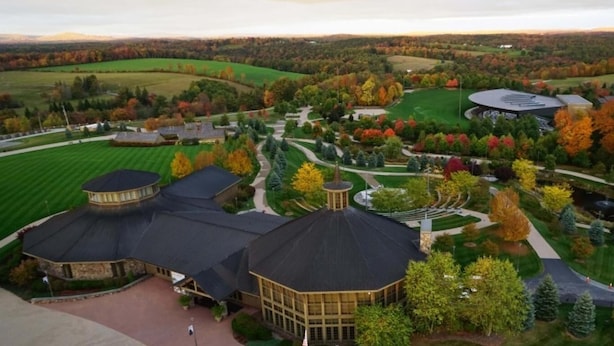 A large, landscaped property with multiple buildings, including a central structure with a dome roof and several smaller buildings with similar roofs.
