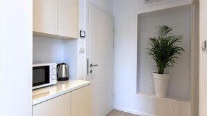 A compact kitchen with a microwave, kettle, and a potted plant. - Via Porto Rooms - Deluxe Double Room with Double Bed and Balcony (Split)