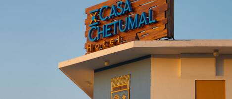 A hotel sign with a wooden facade and a balcony.