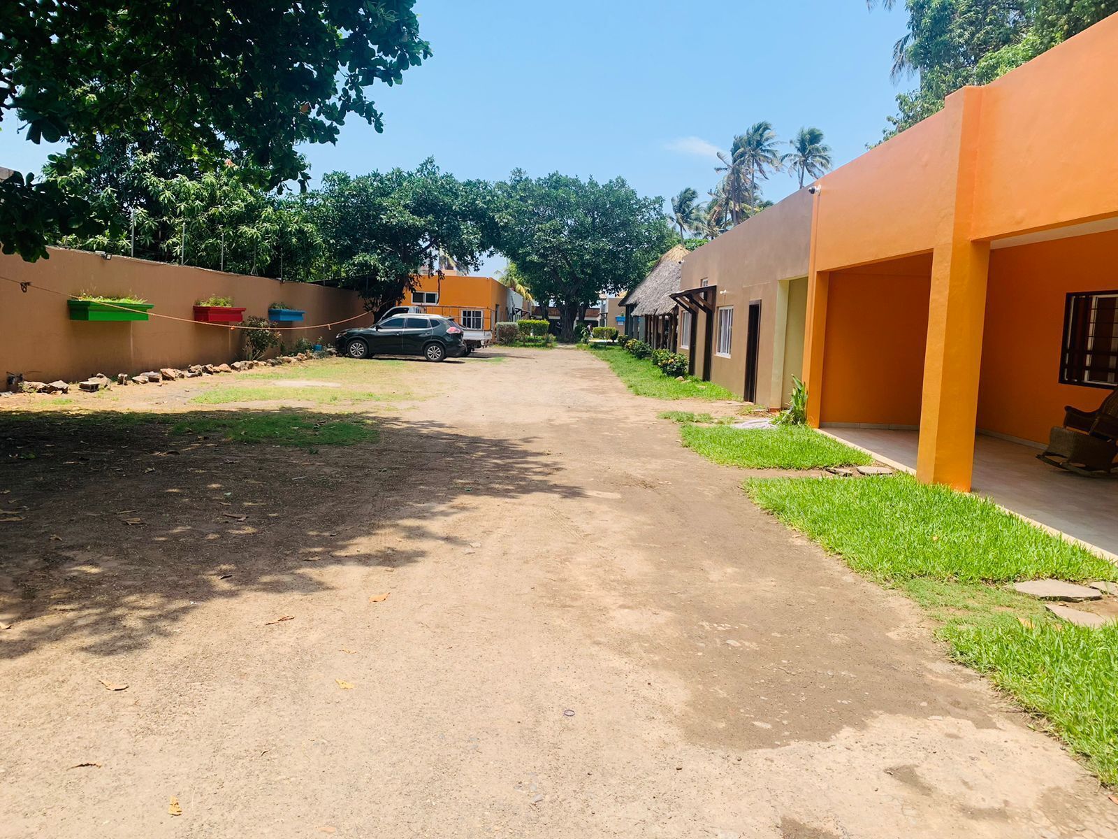 A residential street with houses, a parked car, and a clear sky.