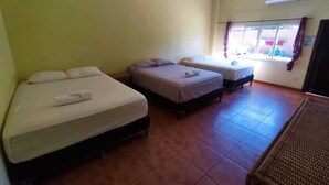 A room with three beds, a window with curtains, and an air conditioning unit. - Hotel Fragatta playa el cuco  (El Cuco)