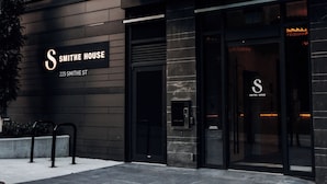 A modern building with a sign reading "Smith House" at 225 Smith St. - Smithe House (Vancouver)