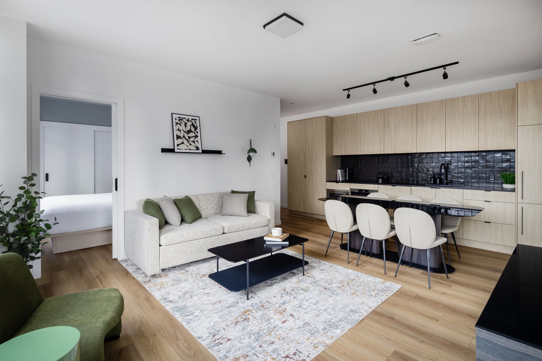 A modern apartment with a living room, dining area, and kitchen.