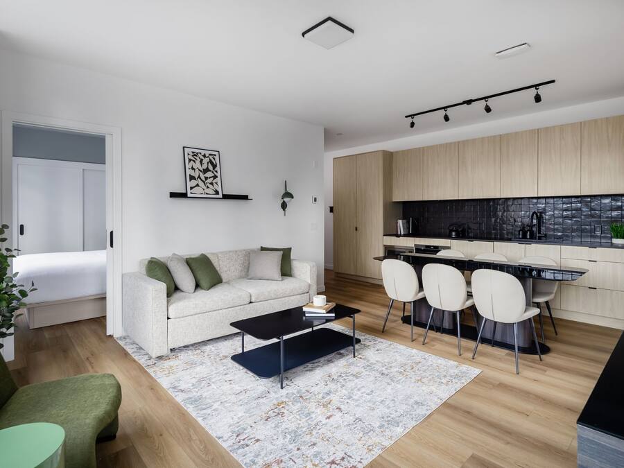 A modern apartment with a living room, dining area, and kitchen.