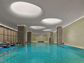 A modern indoor swimming pool with a clear blue mosaic floor, recessed lighting, and a minimalist design. - Doubletree By Hilton Chengdu Xinglong Lake (Chengdu)
