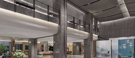 A spacious lobby with high ceilings, marble flooring, and modern lighting fixtures.
