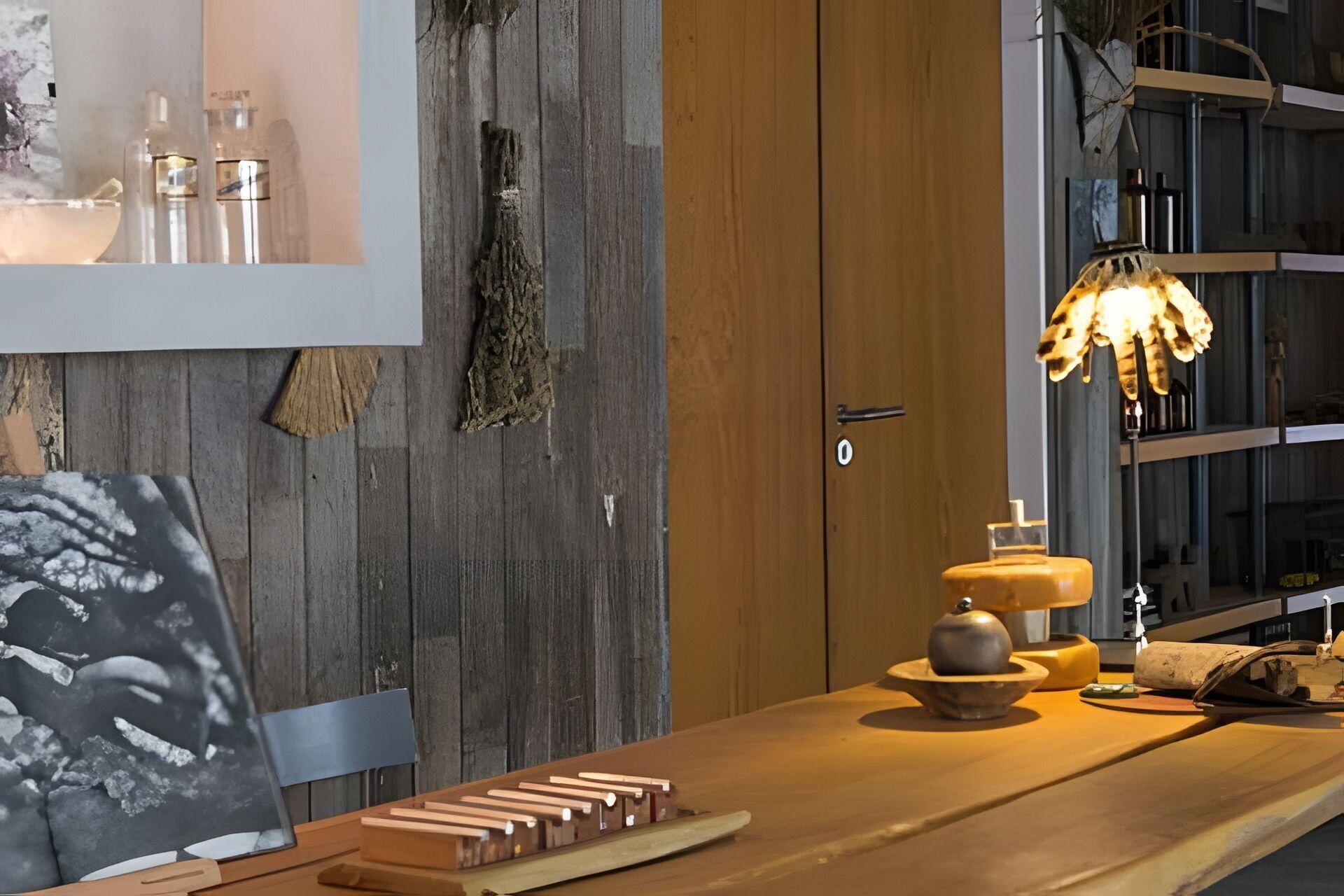 A wooden table with a board game, a lamp, and a decorative bowl.