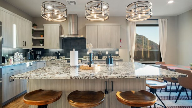 A modern kitchen with a large island, bar stools, and pendant lighting. - Luxury Oasis • Pool, Pickleball, Stargazing Views (Kanab)