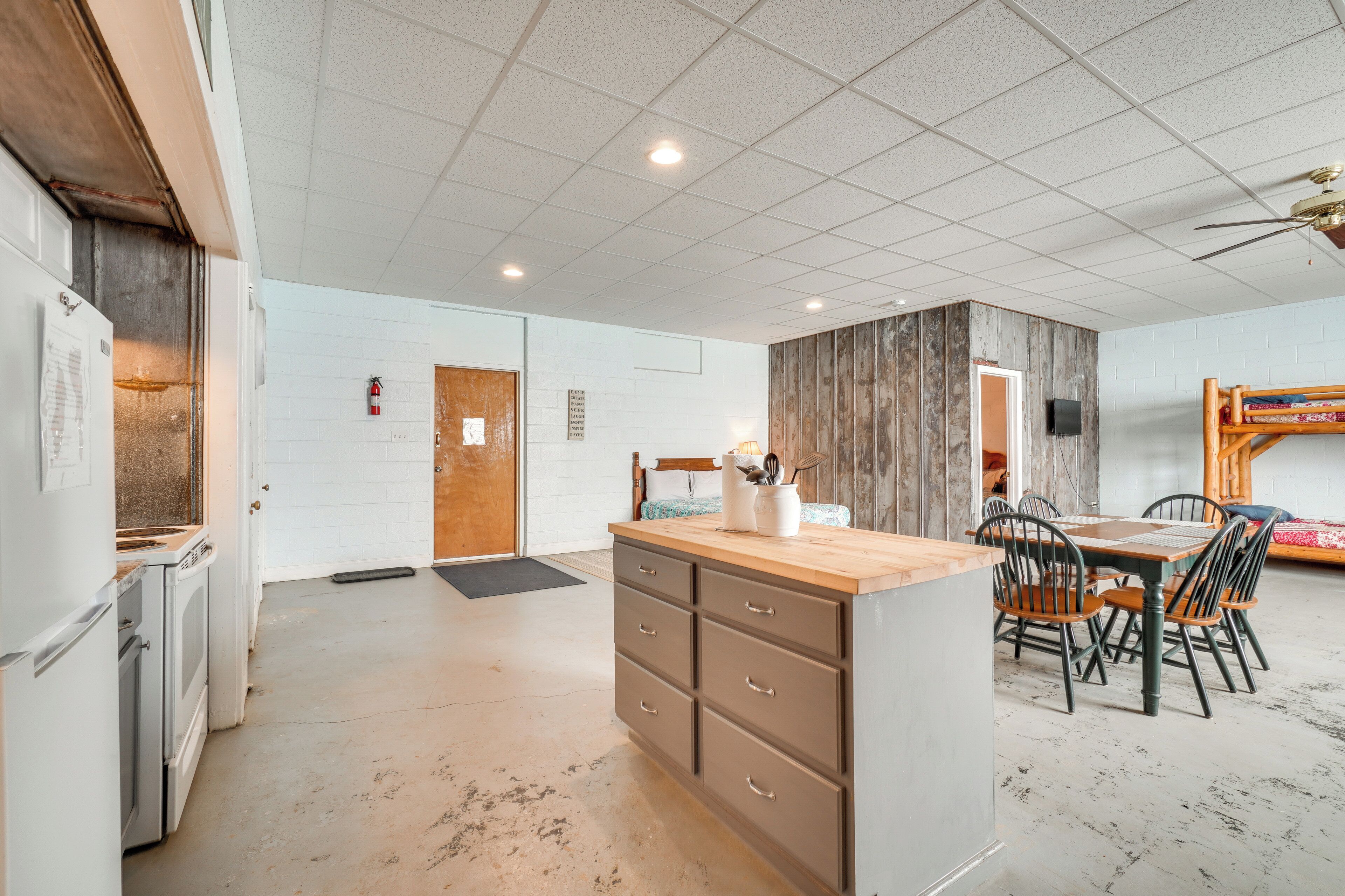 Una cocina amplia con una isla central, armarios de madera y un comedor con sillas y mesa.