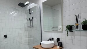 A modern bathroom with a white sink, mirror, and toilet. - Collins St - The Heart Of The City (Melbourne)