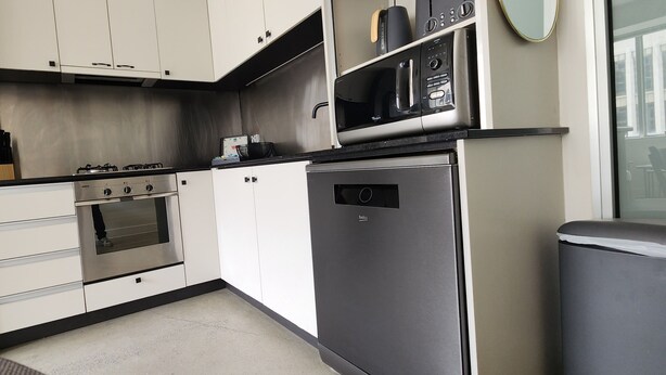 A compact kitchen with a Bosch gas stove, a built-in oven, a refrigerator, and a microwave. - Collins St - The Heart Of The City (Melbourne)