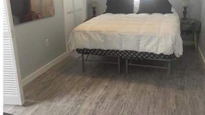 A bedroom with a bed, a ceiling fan, a window, and a painting on the wall. - Tiny Cozy Home in Missouri (Bakersfield)