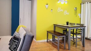 A dining area with a yellow wall, a table, chairs, and a bench. - Spacious full equipped in quiet area w/terrace B (Willemstad)