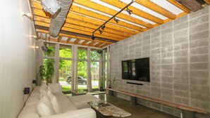 Ein modernes Wohnzimmer mit einer Couch, einem Couchtisch und einem an einer Steinwand befestigten Fernseher.