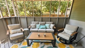 A covered patio with a sofa set, two armchairs, a coffee table, and a patterned rug. - Historic Downtown Frisco- Walk to Dining- 5m to Toyota Stadium- 12m to Universal (Frisco)