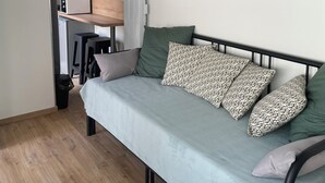 A compact room with a bed, a kitchenette, and a small dining area. - Studio Vichy (Vichy)