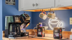 A coffee station with a coffee maker, two coffee pods, and a neon coffee cup sign. - Fun & Funky Asheville Home with Pool Table, Darts (Arden)