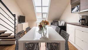 Eine moderne Küche mit Essbereich, einem großen Fenster und einer Treppe.