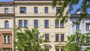 Ein mehrstöckiges Gebäude im klassischen Baustil, mit symmetrisch angeordneten Fenstern und einem zentralen Eingang.