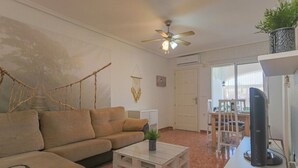A living room with a sofa, coffee table, TV, and ceiling fan. - 090 - Altomar II 005 - comfortHOLIDAYS (el Gran Alacant)
