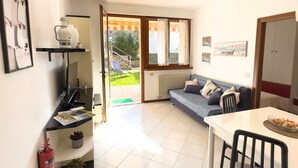 A compact living space with a kitchenette, a dining area, and a sofa. - GIULY BETH'S HOUSE BRENZONE (Assenza)