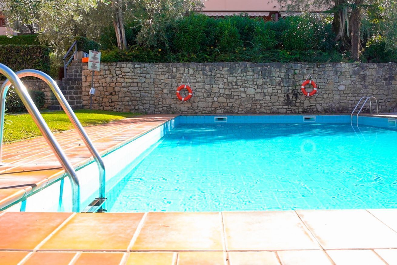 Ein Schwimmbecken mit Steinmauern und Metallleitern.