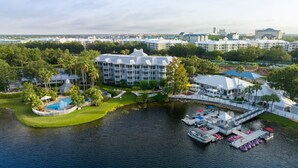 A resort with a large building, a swimming pool, and a dock with boats.