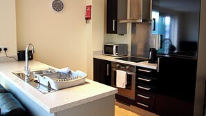 Una cocina moderna con electrodomésticos de acero inoxidable, horno integrado y microondas.