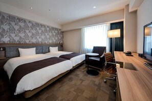 A hotel room with two beds, a desk, a chair, a TV, and a window with curtains.