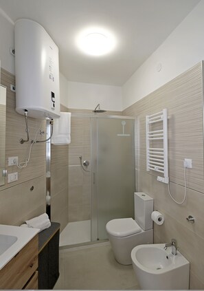 Een douche, een haardroger, een bidet, handdoeken