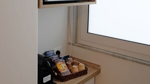 En minibar med mikroovn, vinflasker, glas og en bakke med kaffekopper og kaffemaskine.
