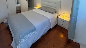 A bedroom with a bed, bedside tables, a wardrobe, and a mirror. - New House, Amazing View (Lisboa)