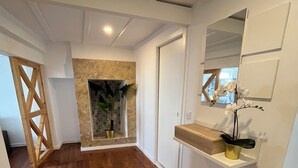 A hallway with wooden flooring, a white wall with a built-in shelf, and a door. - New House, Amazing View (Lisboa)