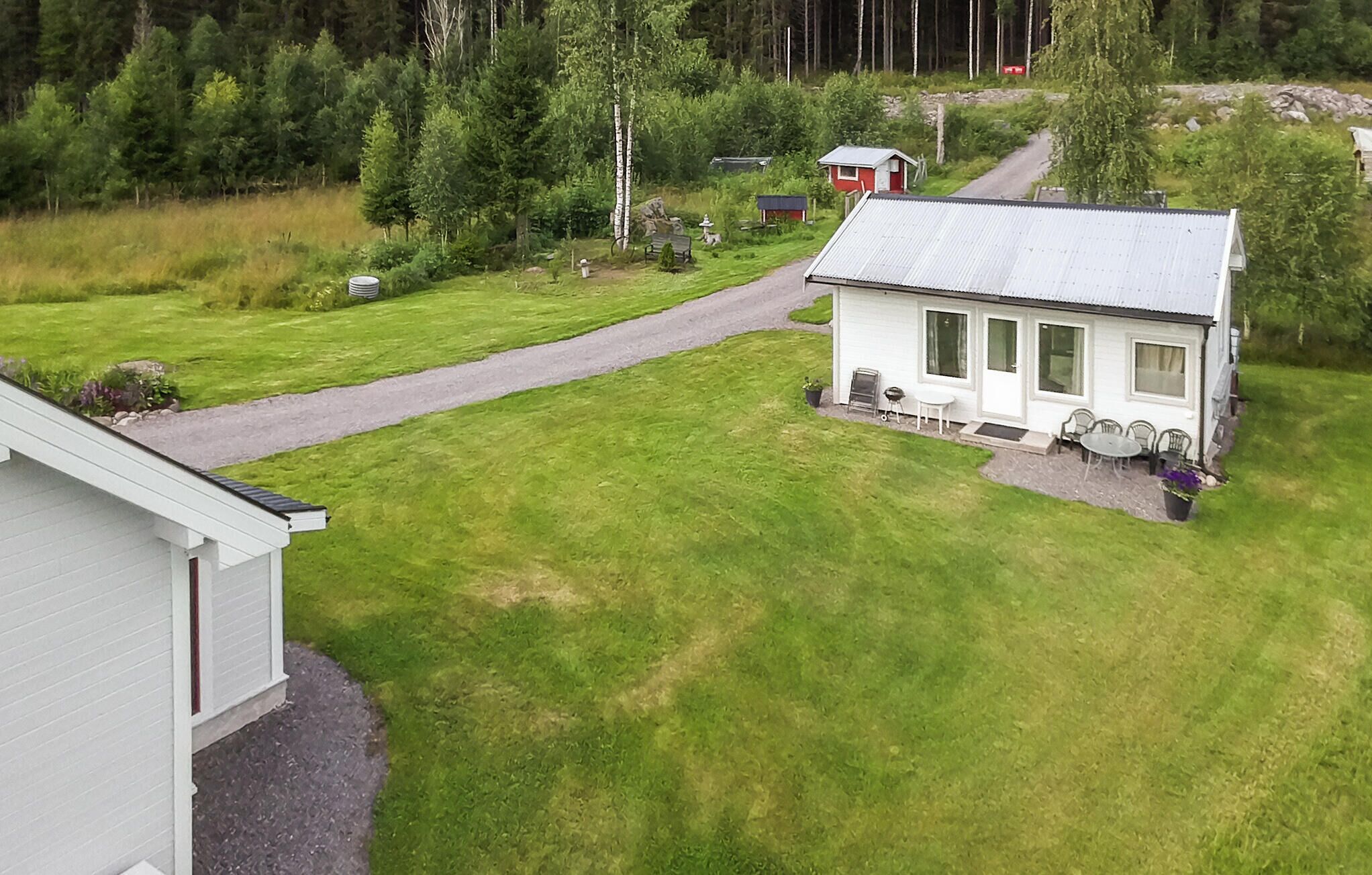 Une petite maison de plain-pied avec une allée pavée menant à la porte d’entrée.