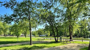 A park with picnic tables and a gravel path.