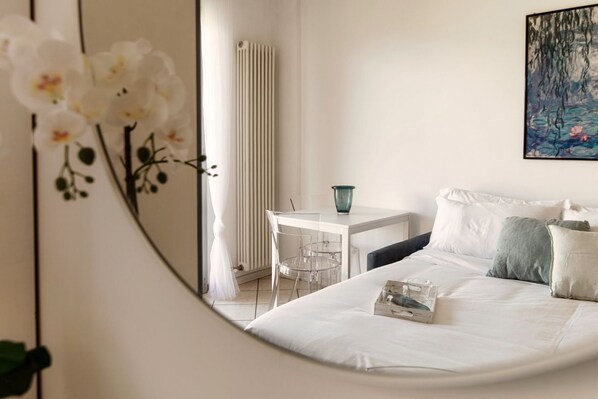 A bedroom with a bed, bedside table, and a chair.