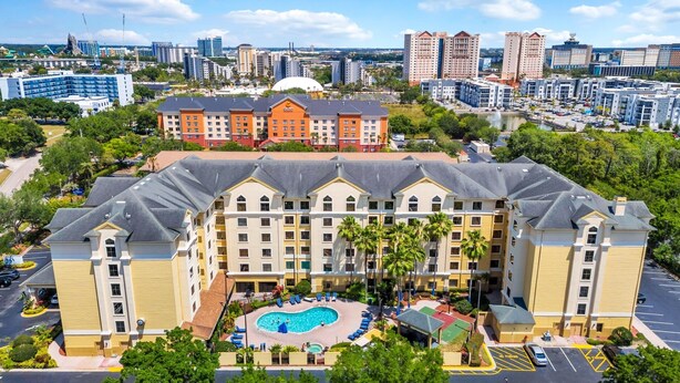 A hotel with a central courtyard, a swimming pool, and a view of the city skyline.