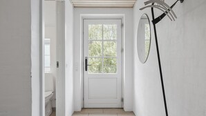 A white door with a window, a mirror on the wall, and a toilet visible to the left. - 7 bedroom lovely home in Ulfborg (Ulfborg)