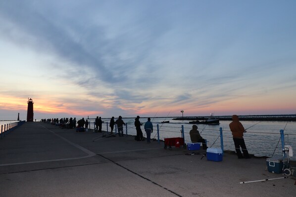 A pier with people fishing at sunset. - Beachwood Home - Muskegon - walk 2 Lake MI BEACH + local playground + pickleball (Muskegon)