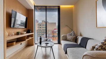 Deluxe Apartment, Balcony, City View | Living area | 40-inch flat-screen TV with cable channels