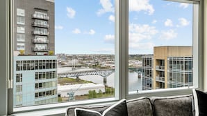 A modern building with a view of a bridge and river. - Luxury high rise condo with river and mountain views, walk to OHSU (Portland)