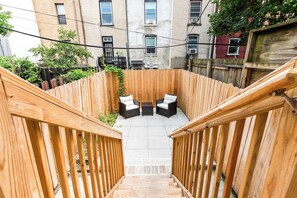 A wooden staircase leading to a patio with outdoor furniture. - 3 LEVEL LUX Townhome! Near MetLife NYC EWR PATH, 4Bed/3Bath! (Jersey City)