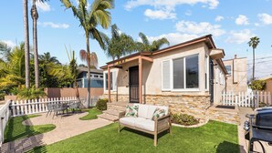 A house with a stone exterior, a front porch, and a lawn. - NEW Private Ocean Beach Home with Yard and Parking (San Diego)