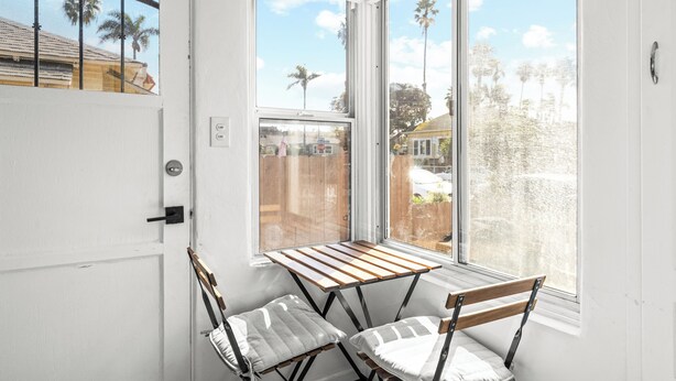 A room with a window, a door, and two chairs. - NEW Private Ocean Beach Home with Yard and Parking (San Diego)