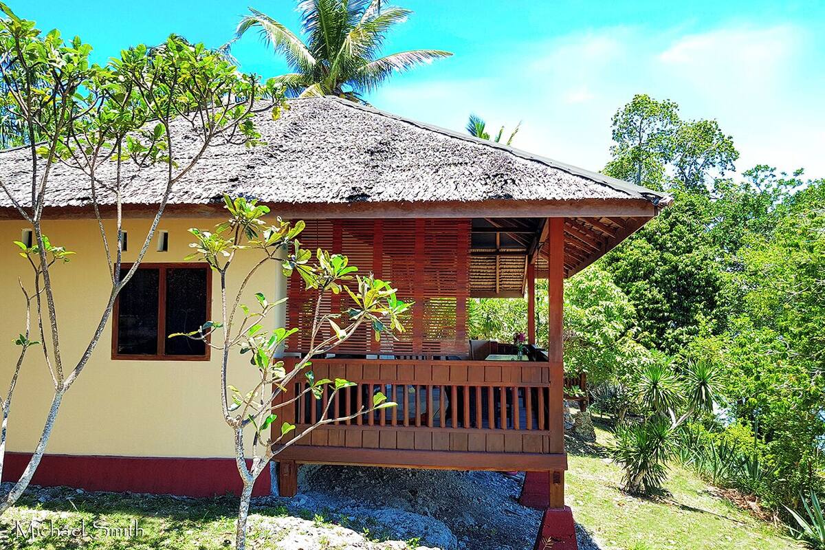 A single-story building with a thatched roof and a wooden porch.