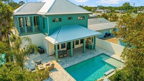 A large house with a swimming pool, covered patio, and a garage. - Exceptional New Build - West End - Pool - Golf Cart (Panama City Beach)