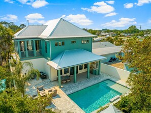 Une grande maison dotée d’une piscine, d’un patio couvert et offrant une vue sur le quartier environnant.